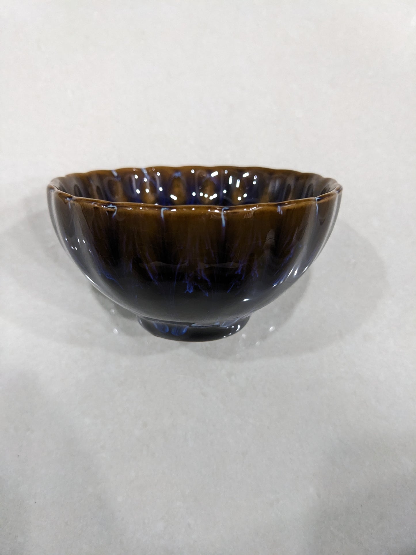 Side view of the vintage ceramic bowl showcasing the deep brown and blue glossy glaze
