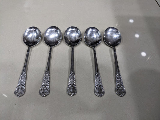 Set of 5 vintage silver-plated spoons with intricate engraved handles lined up together