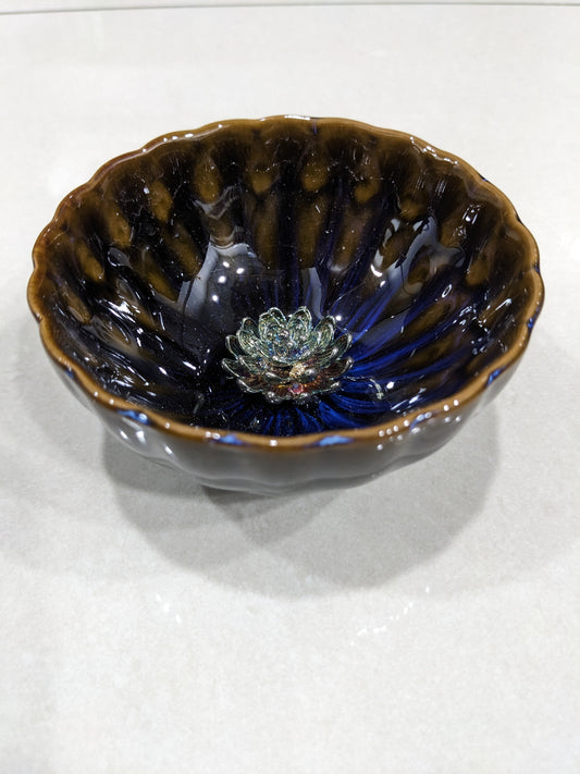 Angled close-up showing the reactive glaze interior and the multi-colored iridescent lotus centerpiece