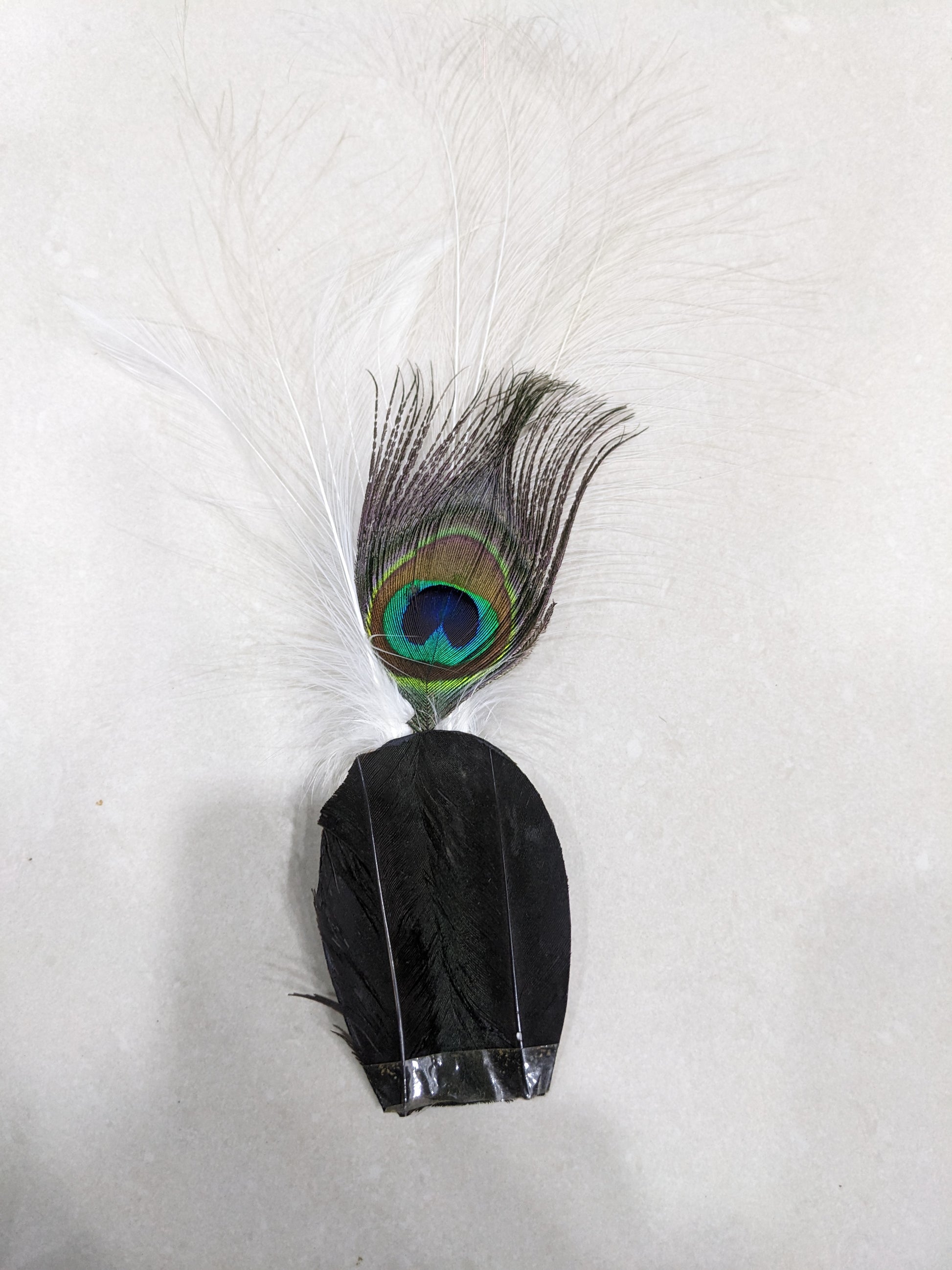 Full view of a vintage hat plume fascinator accessory featuring a natural peacock feather and black base feathers